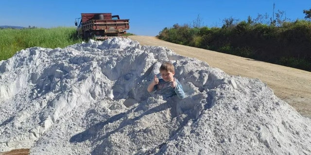 child playing in limestone dust pile
