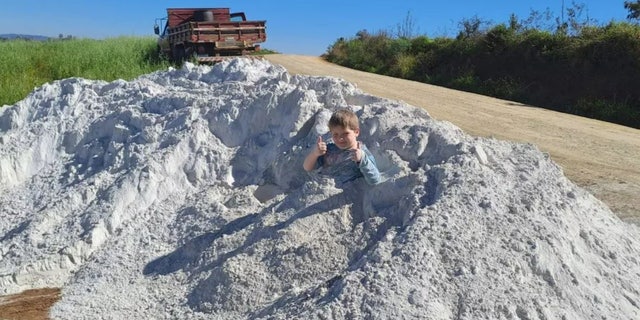 child playing in limestone dust pile