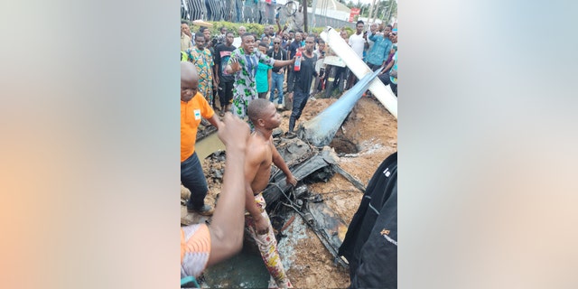 Lagos plane crash wreckage surrounded by onlookers