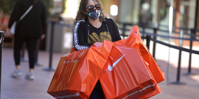 Woman carries bags out of Citadel Outlet mall