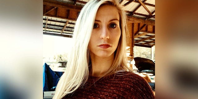 Blonde woman stares at camera in headshot.