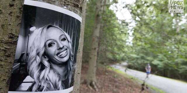 A photo of Rachel Morin is posted on a tree along a hiking route