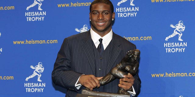 Reggie Bus holds the Heisman Trophy