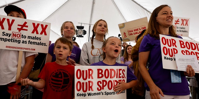 Demonstrators cher during "Our Bodies, Our Sports" speech