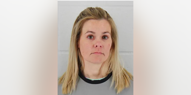 Woman with blond hair in booking photo.