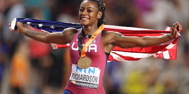 Sha'Carri Richardson runs with American flag