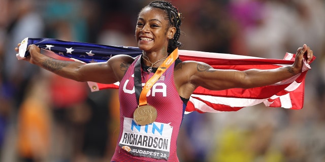 Sha'Carri Richardson runs with American flag