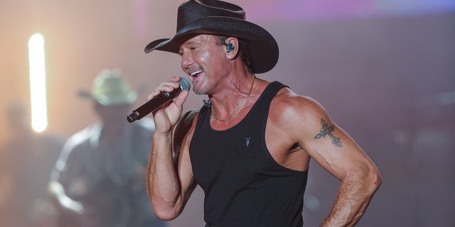 Tim McGraw performs in a tank top