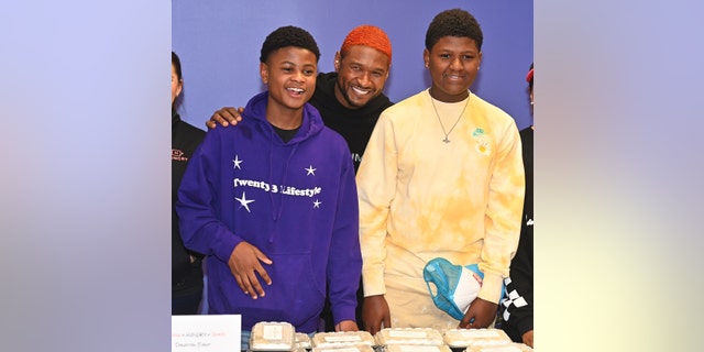 Usher posing with two of his sons