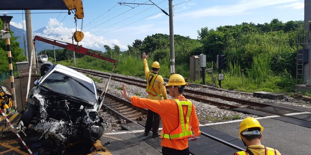 Car removed from site of crash with train