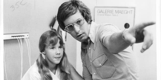 Black and white photo of young Linda Blair being directed by William Friedkin