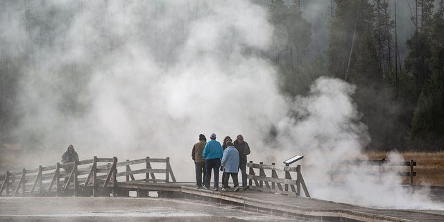 People walk on boardwalk at Yellowstone National Park