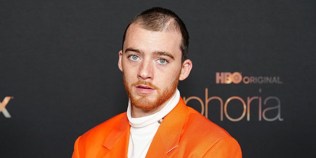 Angus Cloud in a white shirt and orange blazer on the carpet for the "Euphoria" season 2 photo call