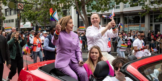Adam Schiff in car with Nancy Pelosi in parade.