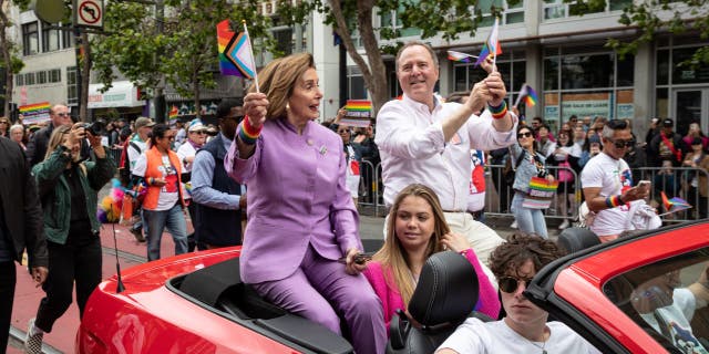 Adam Schiff in car with Nancy Pelosi in parade.