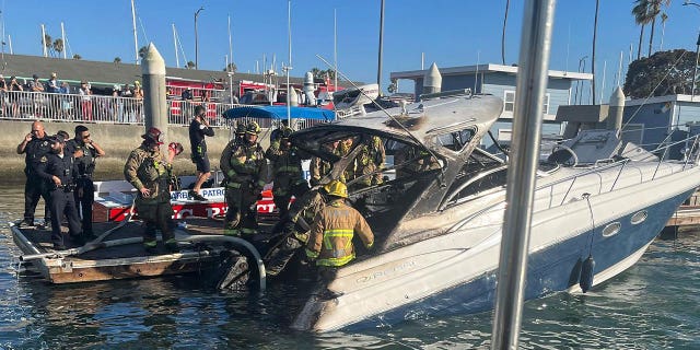 firefighters investigate charred boat 