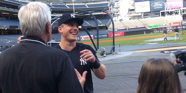 Blakeman and Cardona laugh on the field with Yankees player Harrison Bader