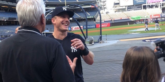 Blakeman and Cardona laugh on the field with Yankees player Harrison Bader