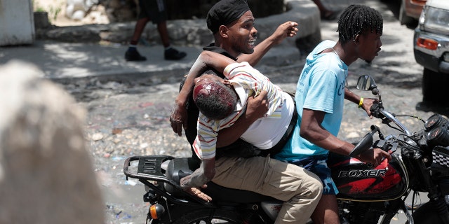 Kenyan police officer holding injured resident