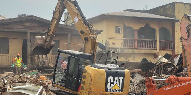 A digger removes debris 