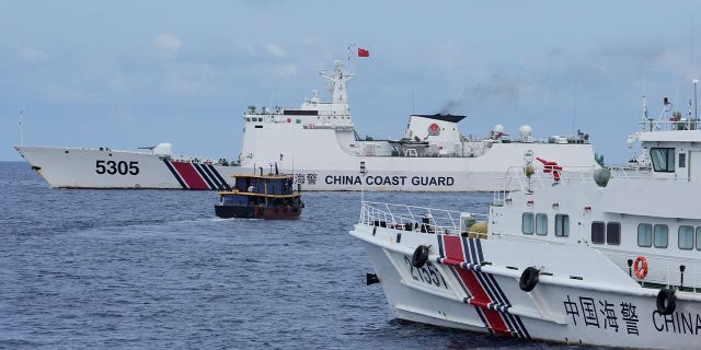 Filipino supply boat maneuvers around Chinese coast guard ships 