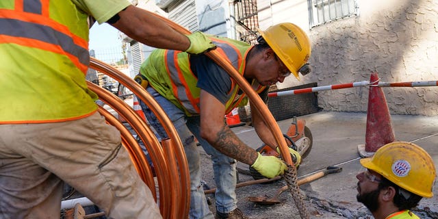 Workers replace pipes