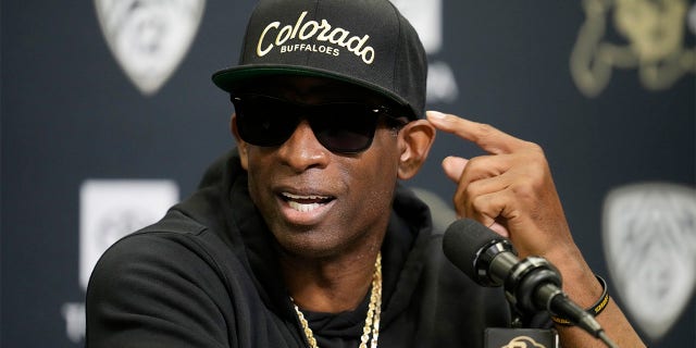 Deion Sanders speaks with reporters