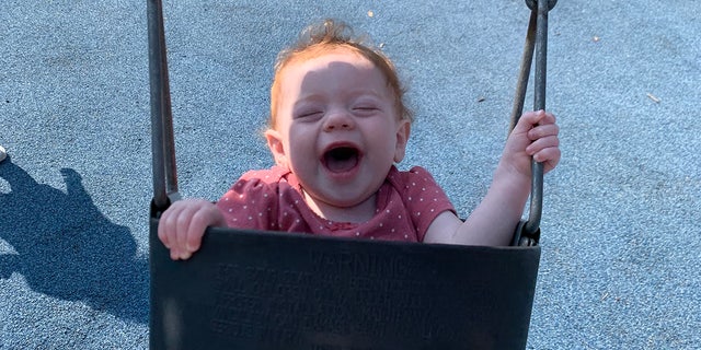 redheaded baby in a child's swing