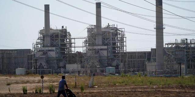 man pushes stroller near power plant