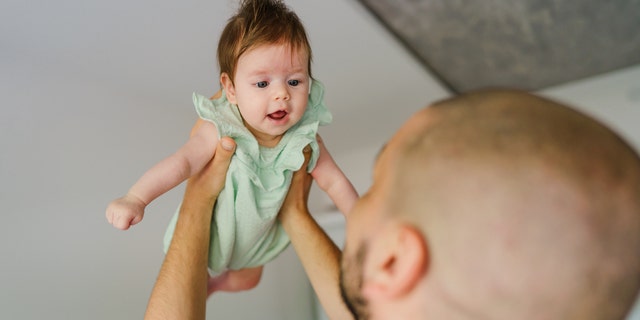 Father throwing baby