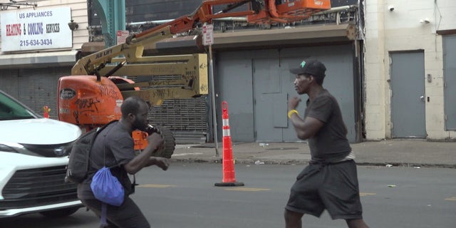 Two people hold their fists up to fight