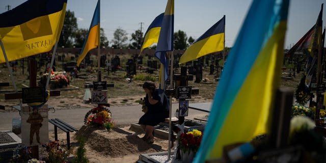 woman cries at her son's grave