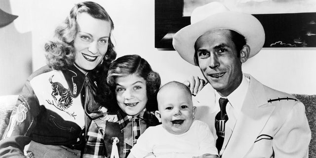 Hank Williams in a light colored hat with his wife, Audrey Williams, her daughter Lycretia from a separate relationship, and Hank Williams Jr. being held by his father