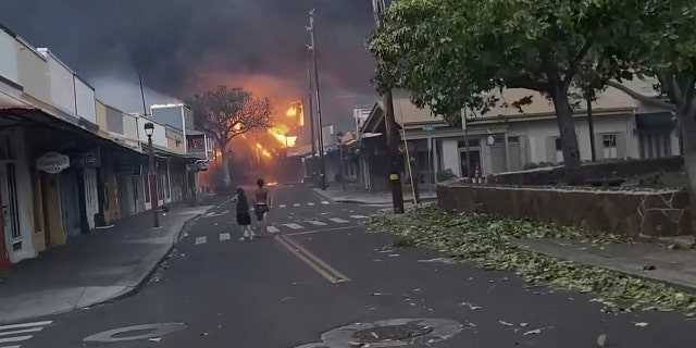people in street as fire rages