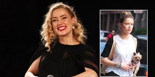 Amber Heard smiling and holding her dog