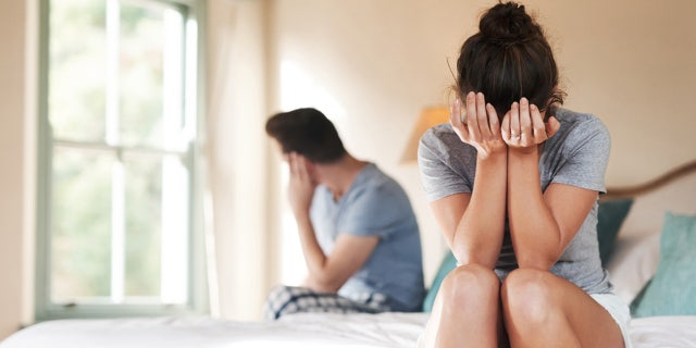 Couple disagreeing on dog in the bed