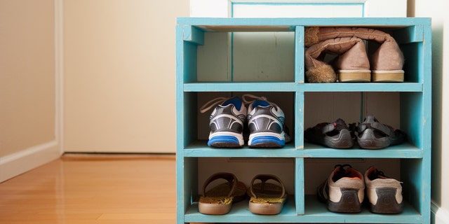 An organized blue shoe rack near an entryway.