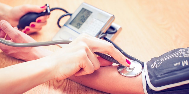 doctor checks patient's blood pressure