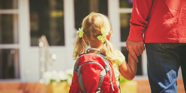 man walking daughter to school
