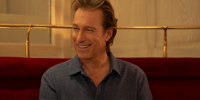 John Corbett smiling in a restaurant booth