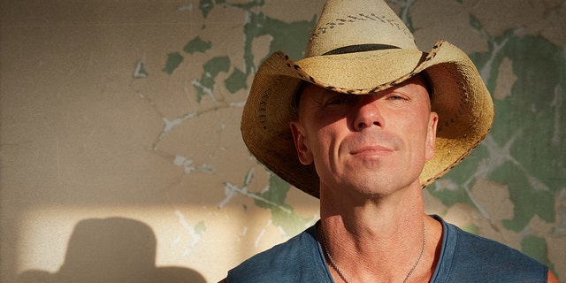Kenny Chesney sports cowboy hat and cut-off shirt