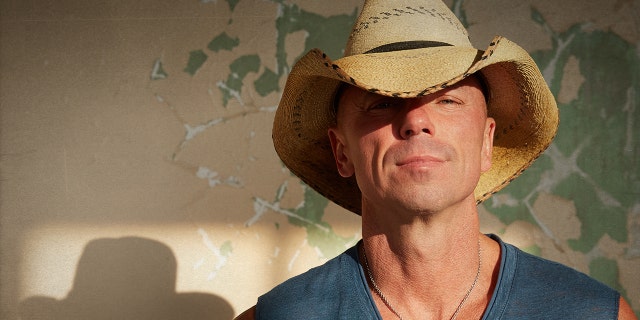 Kenny Chesney sports cowboy hat and cut-off shirt