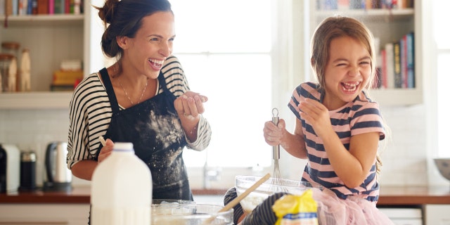 cracking egg trend mother in the kitchen with daughter