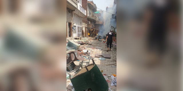 Furniture and other looted property items are tossed about the street in Pakistan