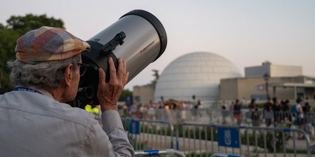 A man looking through a telescope