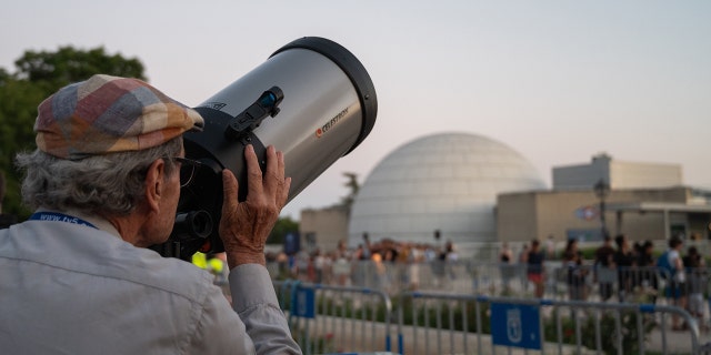 A man looking through a telescope