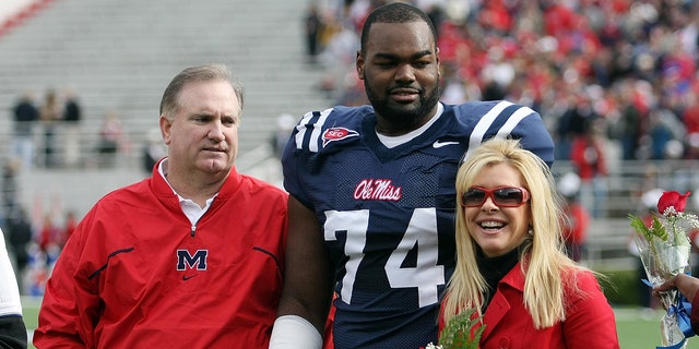 Michael Oher on field with Tuohy family