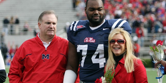 Michael Oher on field with Tuohy family