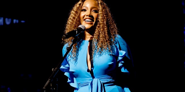 Mickey Guyton wears blue silk dress on stage