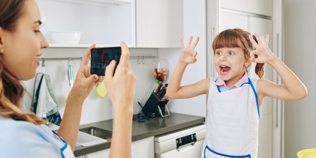 cracking egg trend mom recording daughter for social media